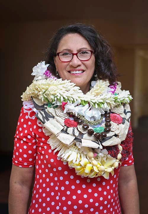 Polynesian woman wearing several flower leis